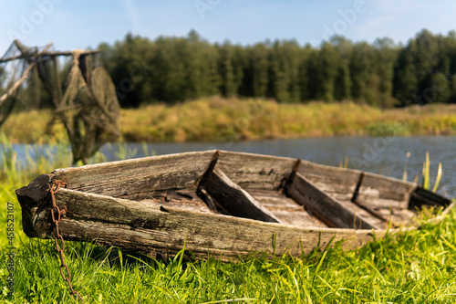 old wooden boat to the shore of the lake on a sunny day.
