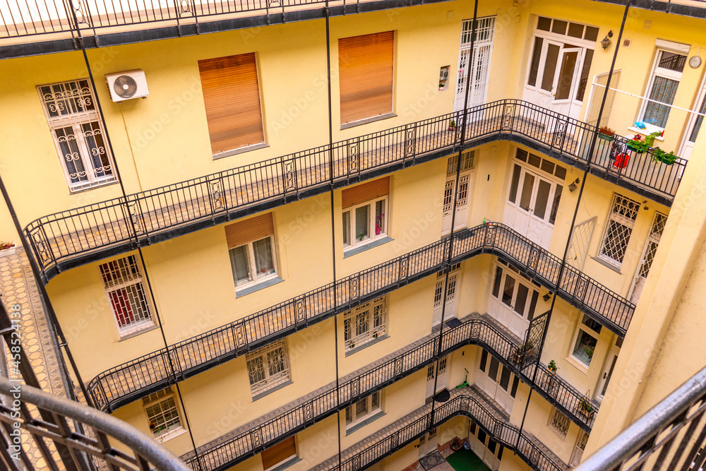 inner courtyard of an apartment building. european archtecture. budapest, hungary. balconies to the courtyard of multi-storey building. view from top floor. Housing conditions in the old town quarter