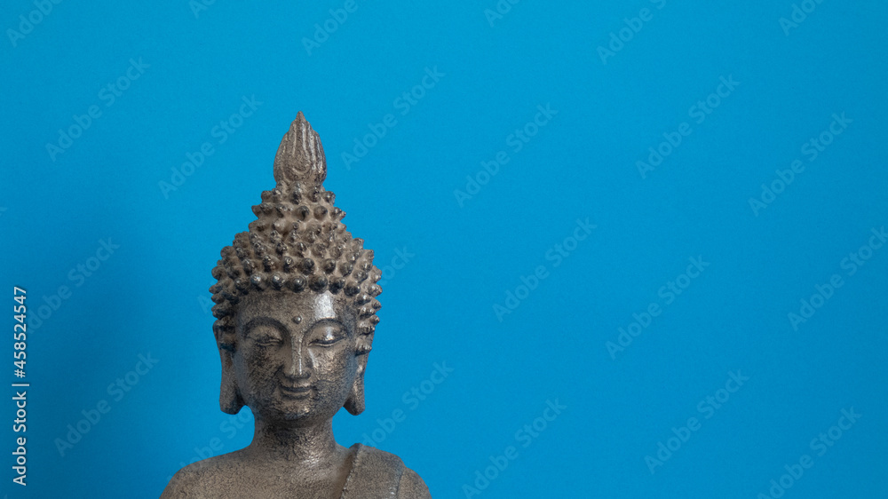 figure gray buddha on blue background