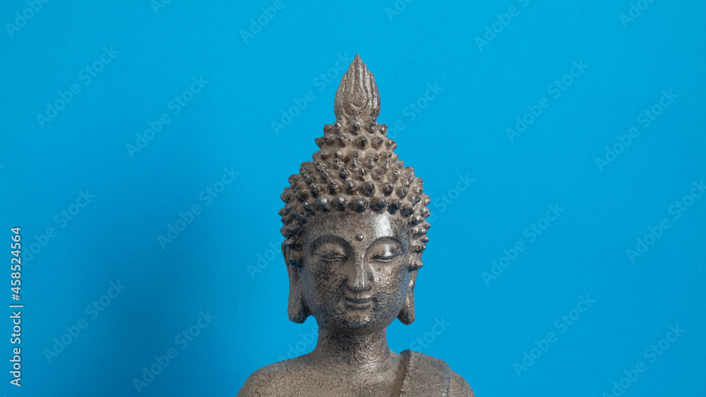 figure gray buddha on blue background