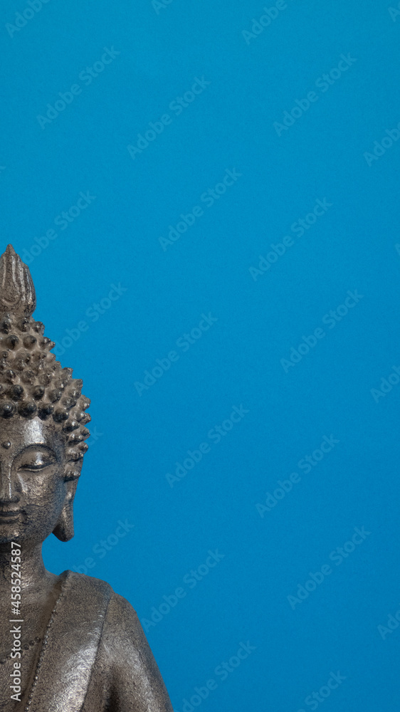 figure gray buddha on blue background