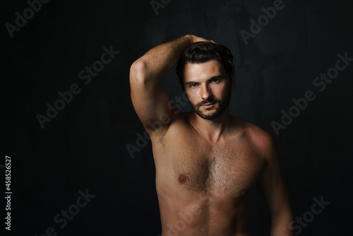 Young half-naked man posing and looking at camera