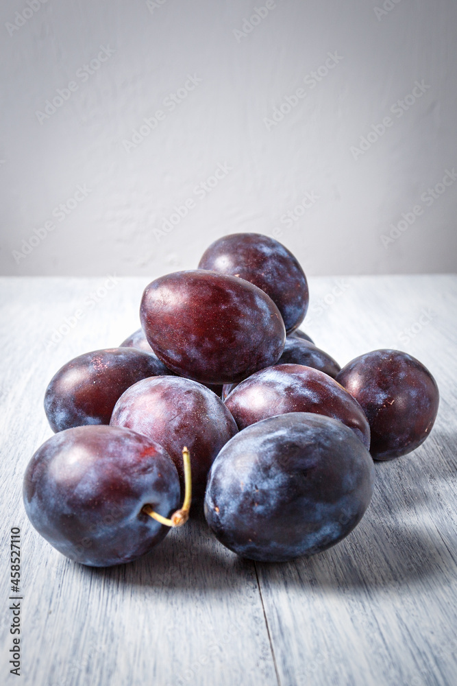 Obraz premium Fresh plums. Fruits. On a white wooden background. Copy space.