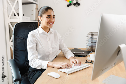 Happy mid aged businesswoman at the desk