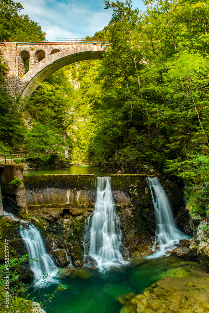 Vintgar Gorge in Slovenia. Stone Arch Rail Bridge over Waterfall