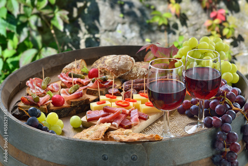 Beim Törggelen in Südtirol mit den klassischen Spezialitäten auf einem Weinfaß dazu regionaler Rotwein