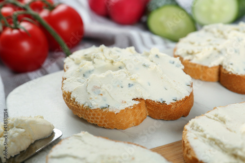 Toasted bread with cream cheese on board, closeup