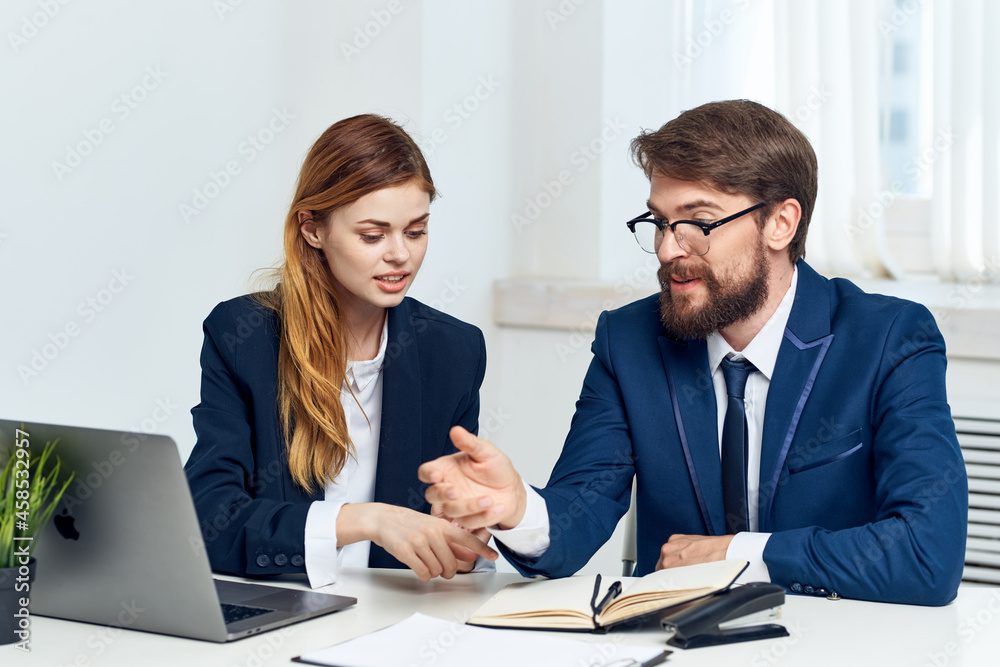man and woman managers work together in front of laptop office technology man and woman managers work together in front of laptop office technology