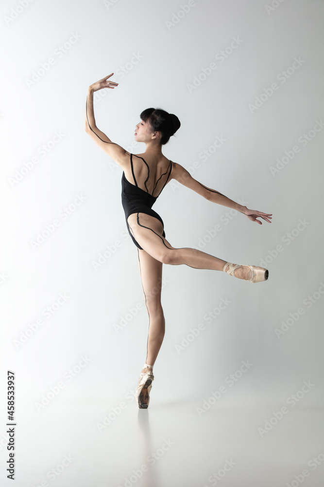 Full-length portrait of graceful ballet dancer, ballerina dancing isolated on light gray studio background. Art, motion, action, flexibility, inspiration concept. Full-length portrait of graceful ballet dancer, ballerina dancing isolated on light gray studio background. Art, motion, action, flexibility, inspiration concept.