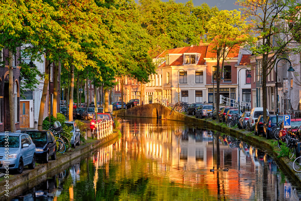 Obraz premium Delt canal with old houses and cars parked along on sunset