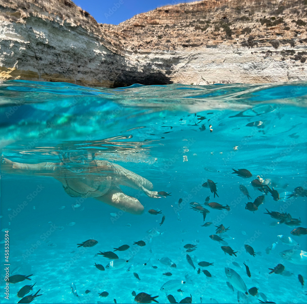 Fototapeta premium ragazza fa snorkeling nel mare di lampedusa
