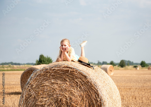 Little girl having fun in a wheat field on a summer day.