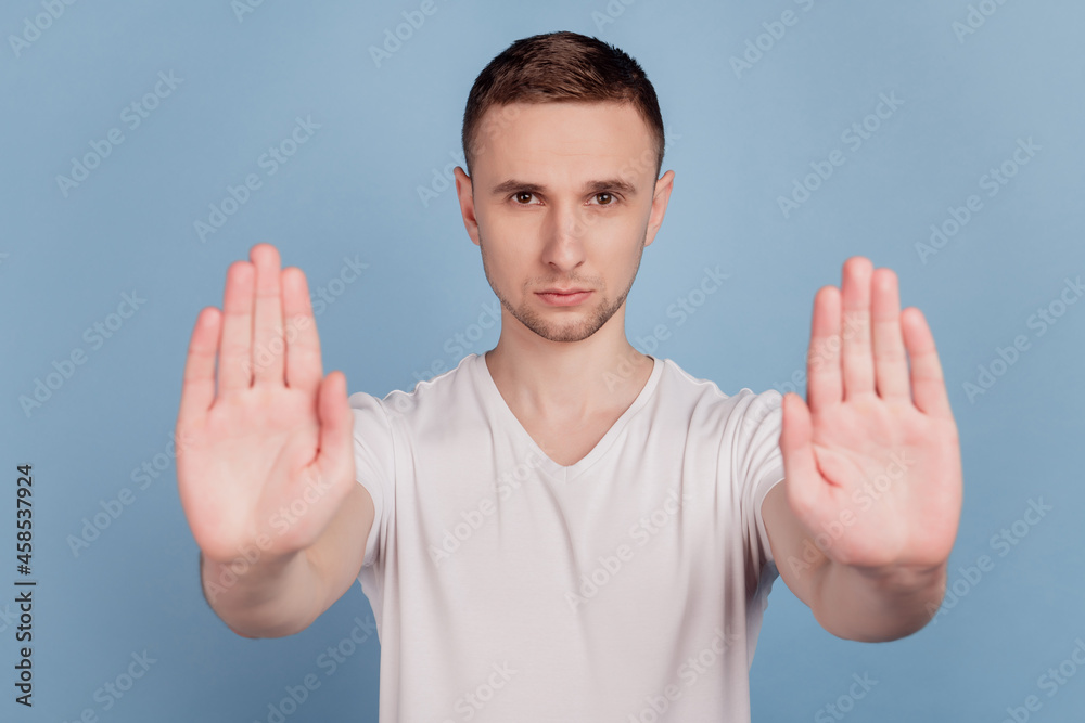Photo of young handsome man unhappy sad show no stop sign enough deny rules isolated over blue color background Photo of young handsome man unhappy sad show no stop sign enough deny rules isolated over blue color background