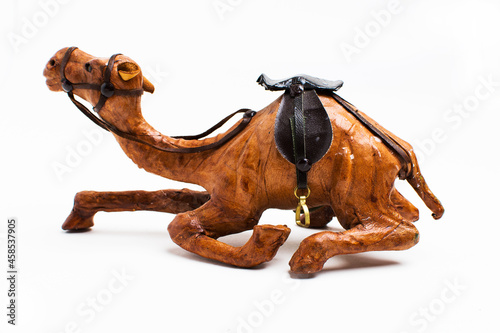 Toy camel resting on a white background