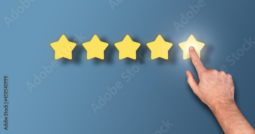 feedback concept, customer giving 5 star rating against blue background with copy space