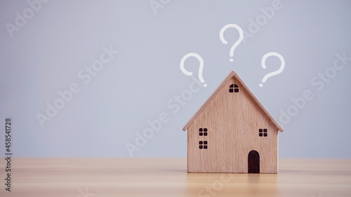 House model with question marks on table background, planning to buy property, loan concept © kelvn