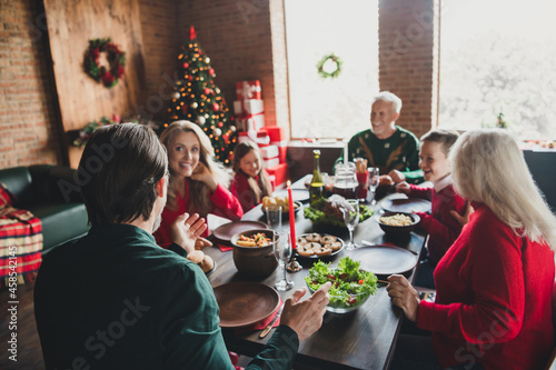 Photo portrait of family sitting at christmas table talking eating spending time together