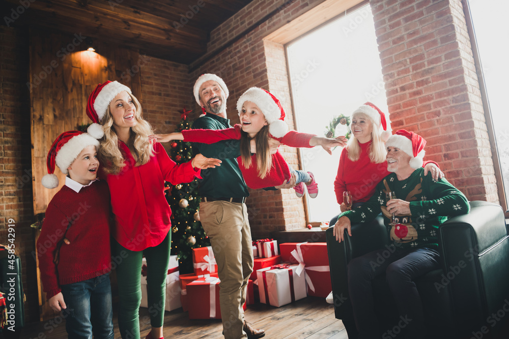 Photo portrait of daddy playing with daughter near grandparents drinking champagne on christmas laughing together