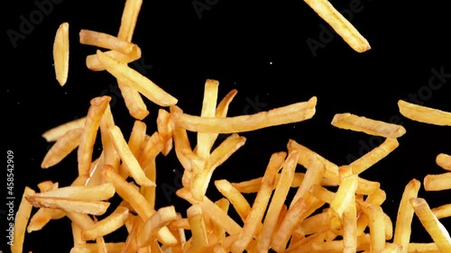 Super slow motion of flying french fries on black background. Speed ramp effect. Filmed on high speed cinema camera, 1000 fps.  photo