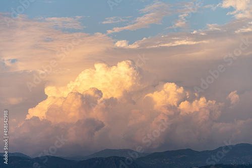 Cloudy orange sunset over the mountains with dramatic clouds