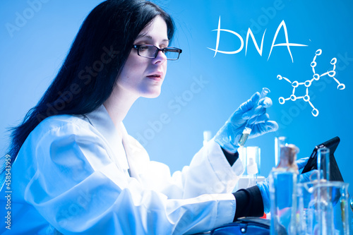 A geneticist conducts research. A female scientist on the background of the inscription of DNA and molecular formula. Genetic research. Genetic engineering. Medicine testing technology. Genetic work.