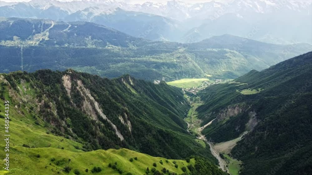 Aerial drone view of nature in Georgia. Caucasus Mountains, greenery, valley, mountain river, village in the distance Aerial drone view of nature in Georgia. Caucasus Mountains, greenery, valley, mountain river, village in the distance