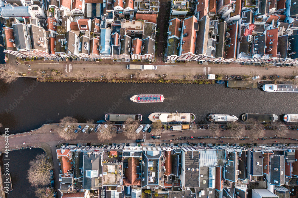 Canal Boat Passing Between Waterfront Houses in Amsterdam Bird's Eye View