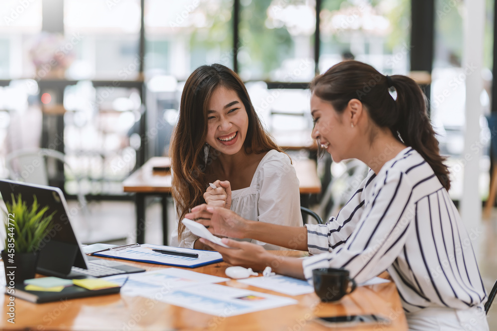 Two young Asian businesswoman are happy working together brainstorm ideas for success using calculator document graph at the office. Two young Asian businesswoman are happy working together brainstorm ideas for success using calculator document graph at the office.