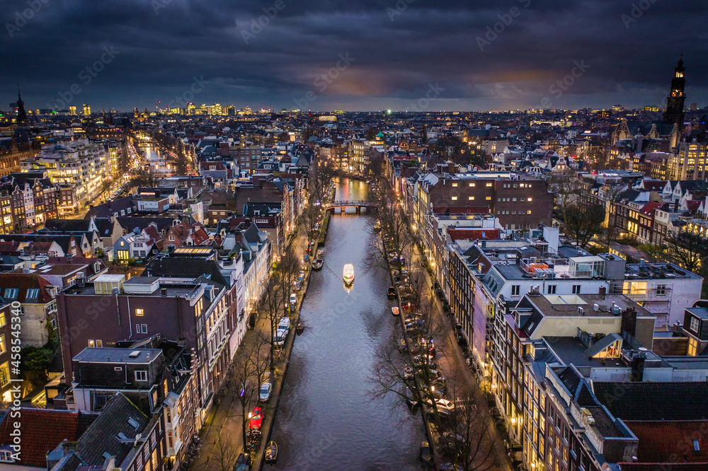Amsterdam City Canals at Night with a Tour Boat Aerial View