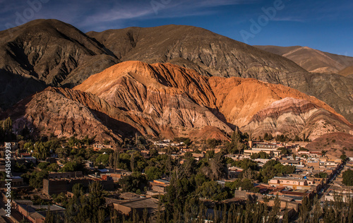 Panoramic shot of the little town of Purmamarca and the seven colours mountain -Cerro de los siete colores- on a sunny morning in Jujuy, Argentina.