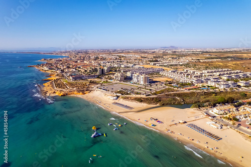 Playa Mil Palmeras drone point of view. Aerial photography sandy beach and Mediterranean Sea at sunny summer day. Travel destinations and tourism concept. Spain, Costa Blanca, Alicante Province. Spain