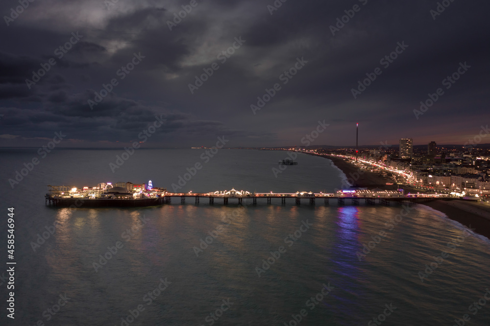 The Seafront Palace Pier in Brighton Illuminated at Night Aerial View The Seafront Palace Pier in Brighton Illuminated at Night Aerial View