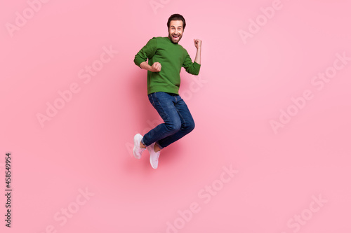 Full length portrait of astonished person raise fists shout yes success isolated on pink color background