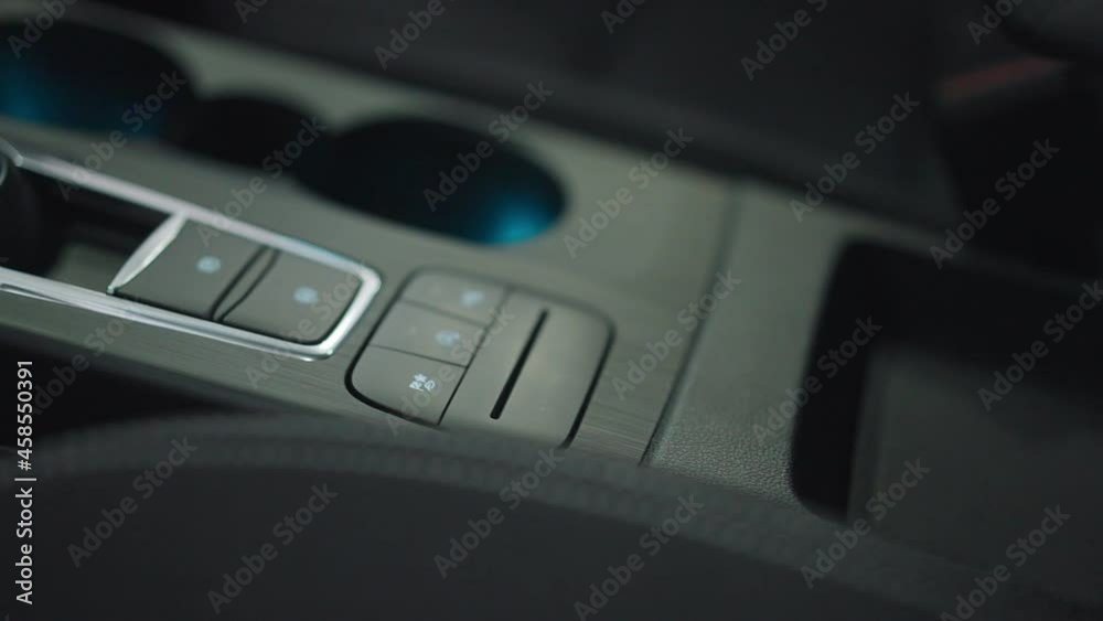 Close-up black car control panel with buttons inside automobile. Luxurious interiors of expensive vehicle part in dealership. Auto industry and advertising concept Close-up black car control panel with buttons inside automobile. Luxurious interiors of expensive vehicle part in dealership. Auto industry and advertising concept