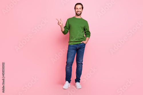 Full length portrait of glad person direct finger empty space proposition isolated on pink color background