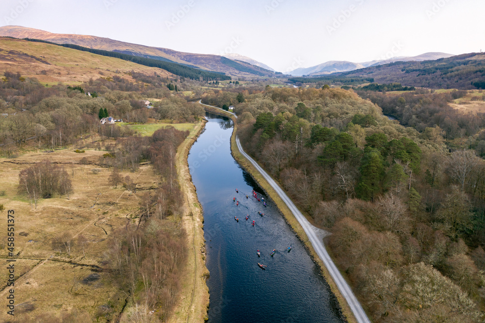 A Group of Canoeists Paddling Along a River Surrounded by Beautiful Landscape