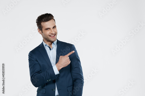 Smiling european business man pointing with finger