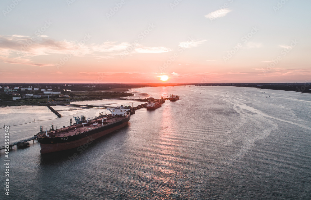 Naklejka premium Cargo Ships at a Small Dock Offloading Goods
