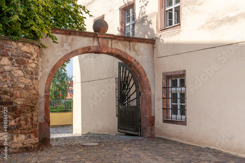 archway with sandstone elements in the old town of Colditz, Saxony in Germany. Path with cobblestones and old house with mullioned windows photo