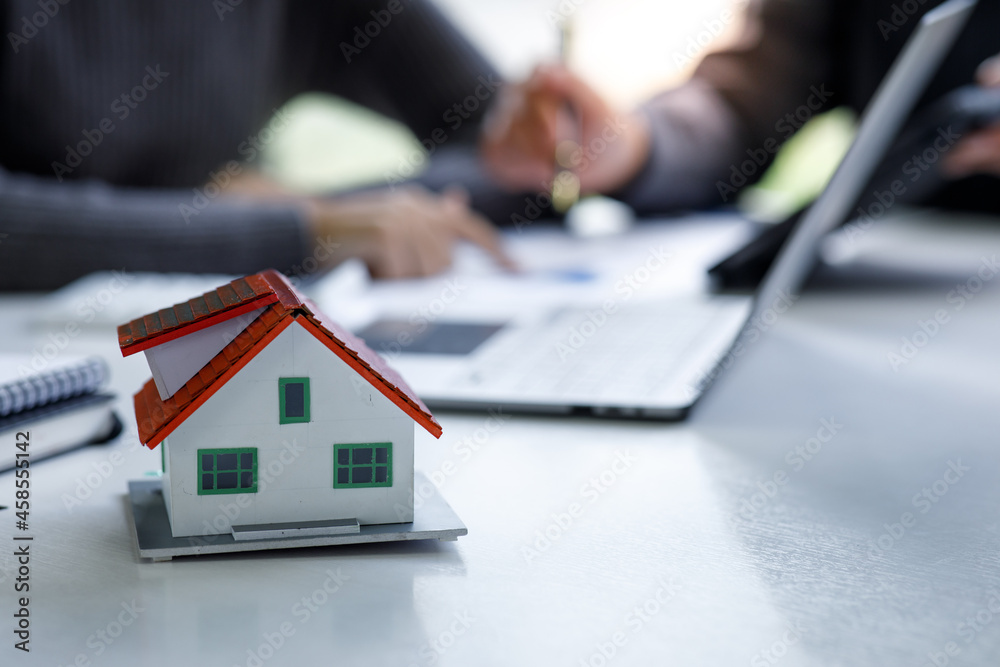 Close-up house model with businessman signs a purchase contract or mortgage for a home, Real estate concept. Close-up house model with businessman signs a purchase contract or mortgage for a home, Real estate concept.