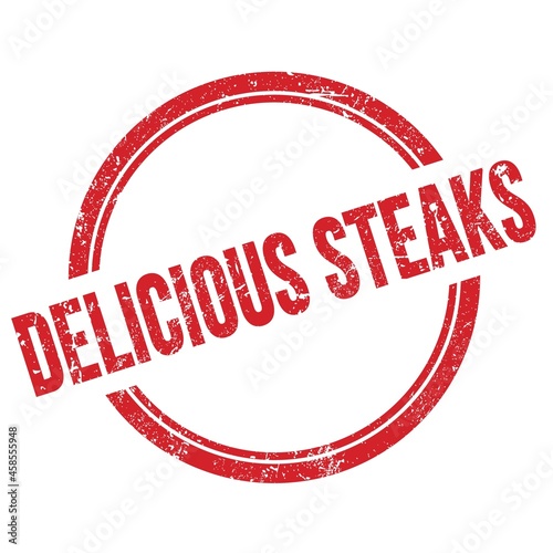 DELICIOUS STEAKS text written on red grungy round stamp.