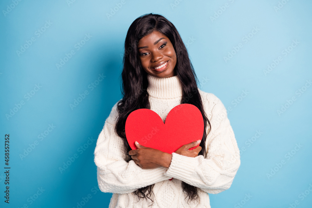 Photo of funny dreamy dark skin lady wear white winter outfit hugging big red heart isolated blue color background Photo of funny dreamy dark skin lady wear white winter outfit hugging big red heart isolated blue color background