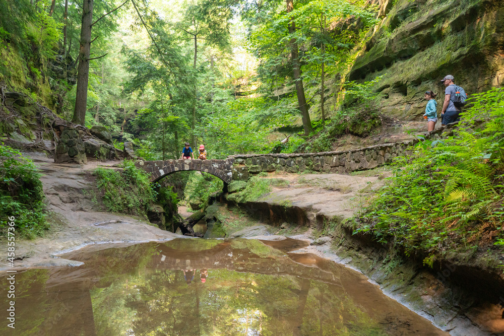 © Sarah Rypma - Family hiking outdoors across a bridge in the forest near Hocking Hills State Park in Ohio © Sarah Rypma - Family hiking outdoors across a bridge in the forest near Hocking Hills State Park in Ohio