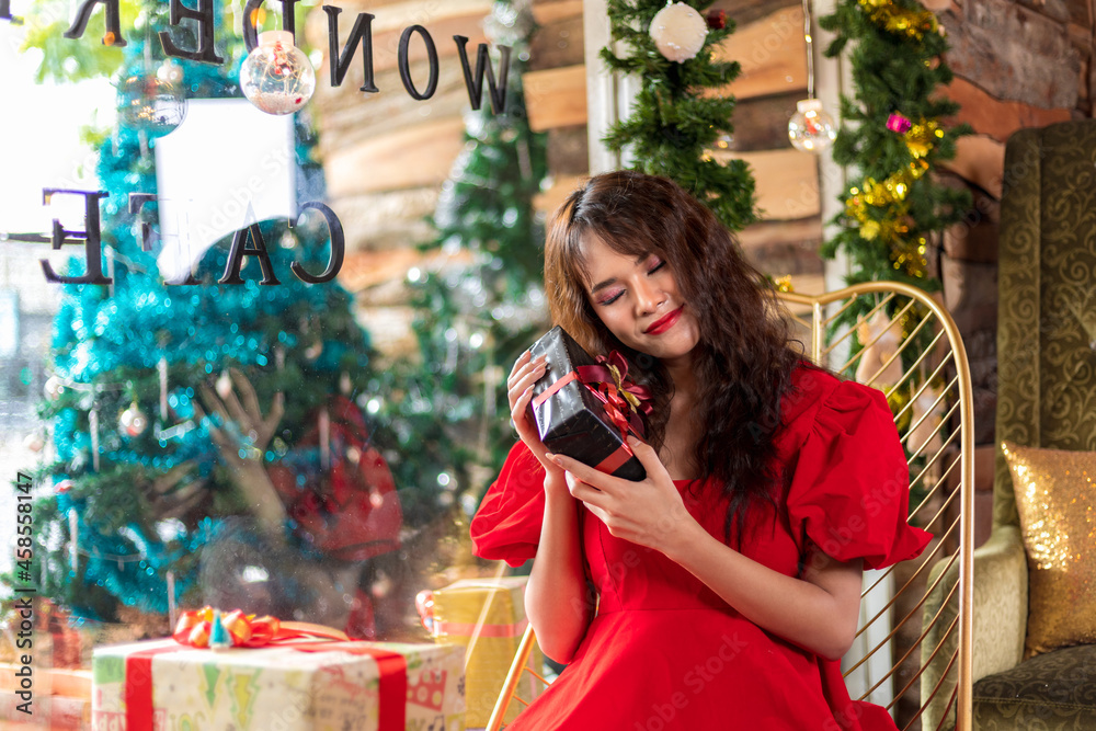 Obraz premium Asian woman smiling happily receiving a big gift box on Christmas day