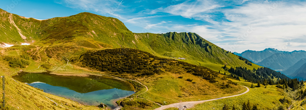 Fototapeta premium High resolution stitched panorama of a beautiful alpine summer view with reflections in a lake at the famous Fellhorn summit near Oberstdorf, Bavaria, Germany