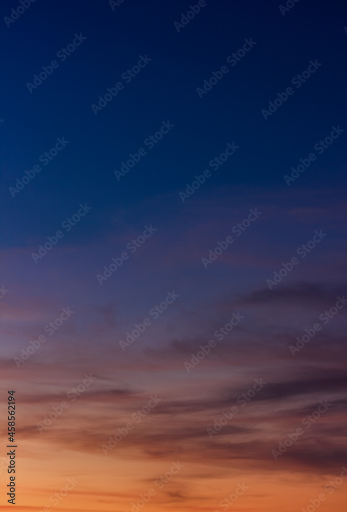 Colorful sunset sky vertical in the evening on twilight with orange sunlight on dark blue hour background