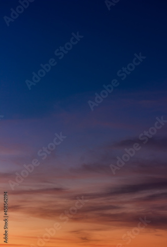Colorful sunset sky vertical in the evening on twilight with orange sunlight on dark blue hour background