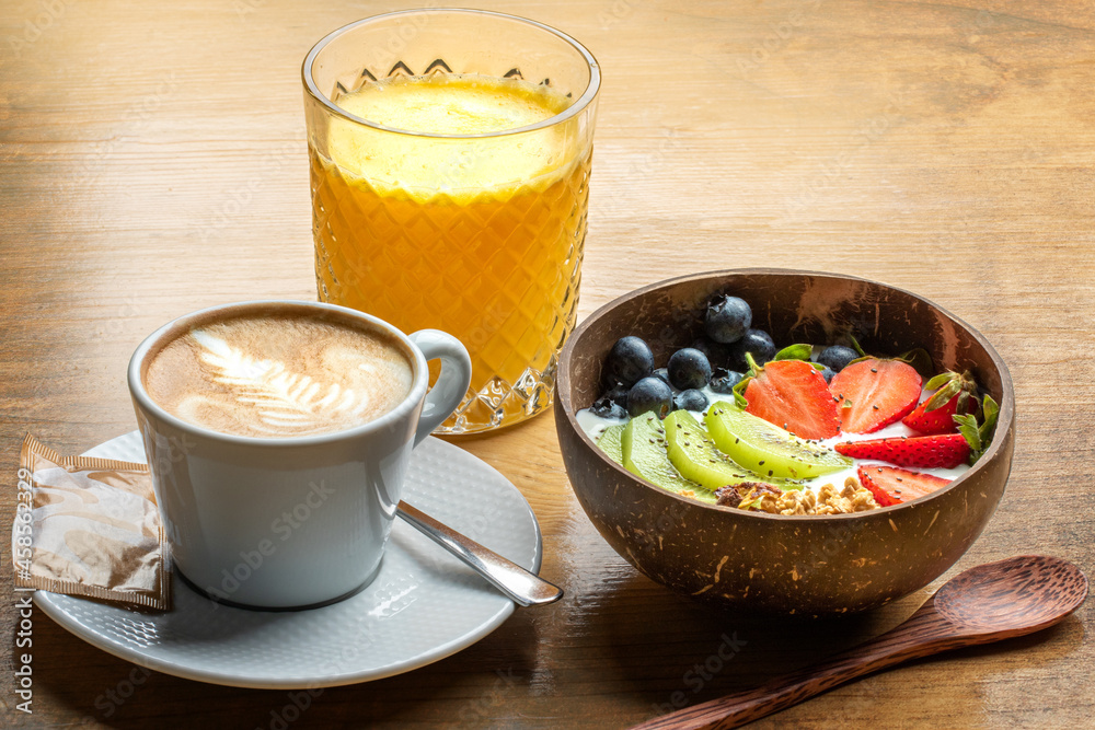 Close up of healthy breakfast with fresh fruit bowl, orange juice and creamy coffee. Close up of healthy breakfast with fresh fruit bowl, orange juice and creamy coffee.