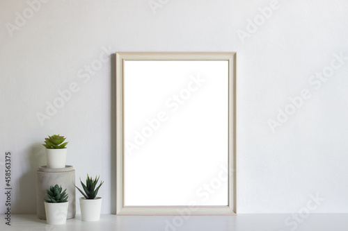 Empty white photo frame with cultus over the light wall.