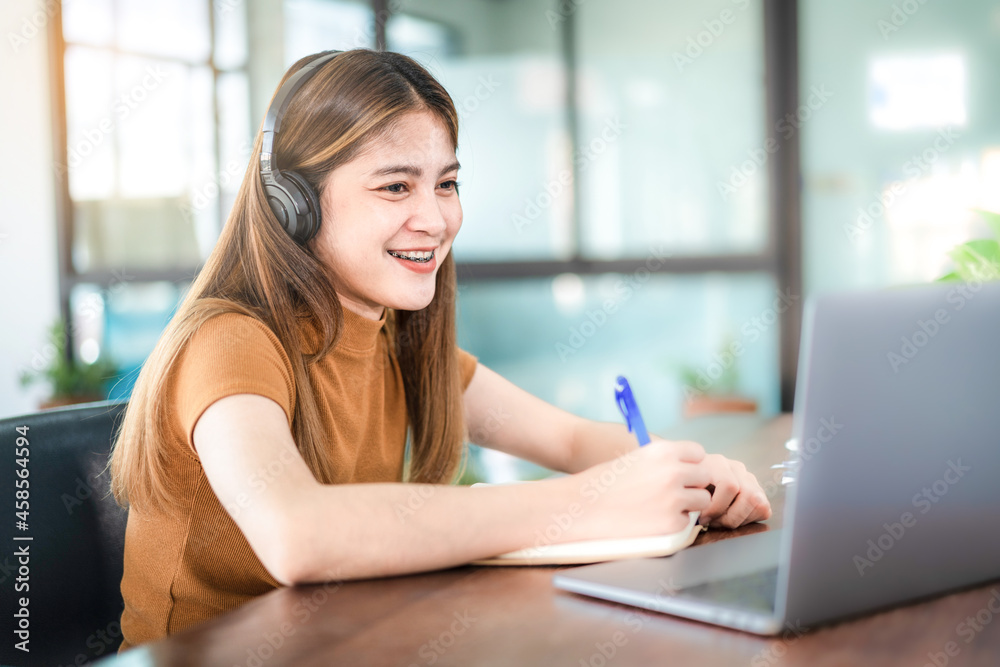 Young Woman College Student Wears Headphone Look at Laptop Study Online at Home Young Woman College Student Wears Headphone Look at Laptop Study Online at Home
